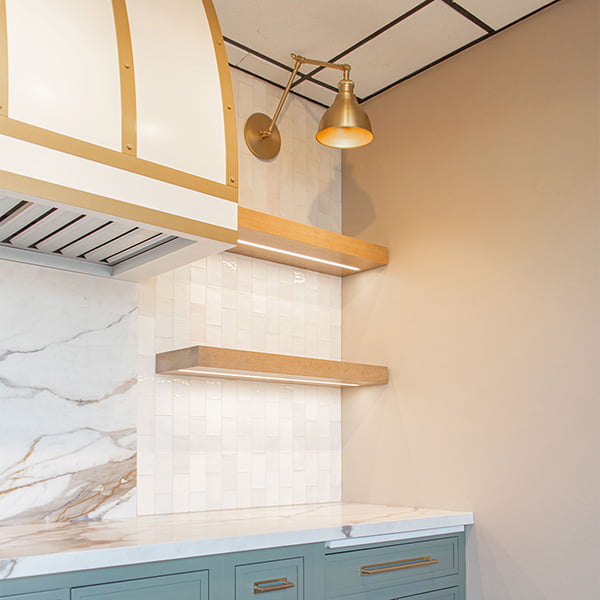 floating shelves in kitchen sitting underneath gold light fixture