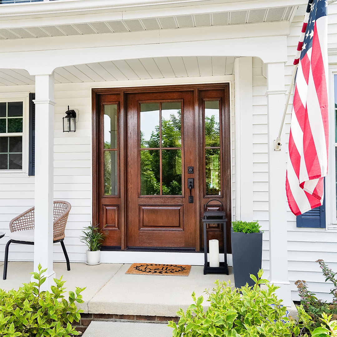 woodgrain fiberglass entry door on white colonial-style home