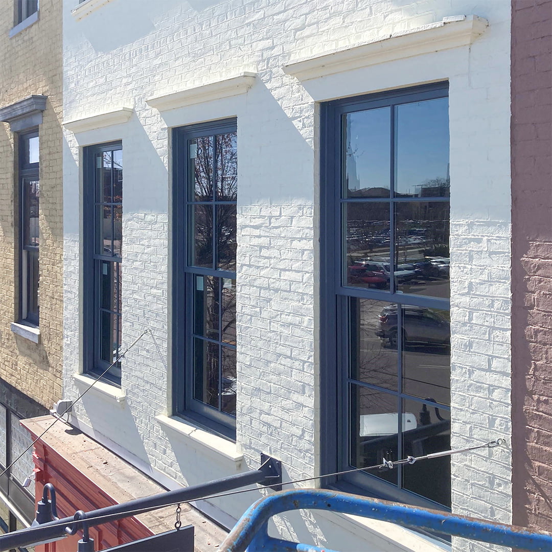 blue aluminum windows on building with white brick