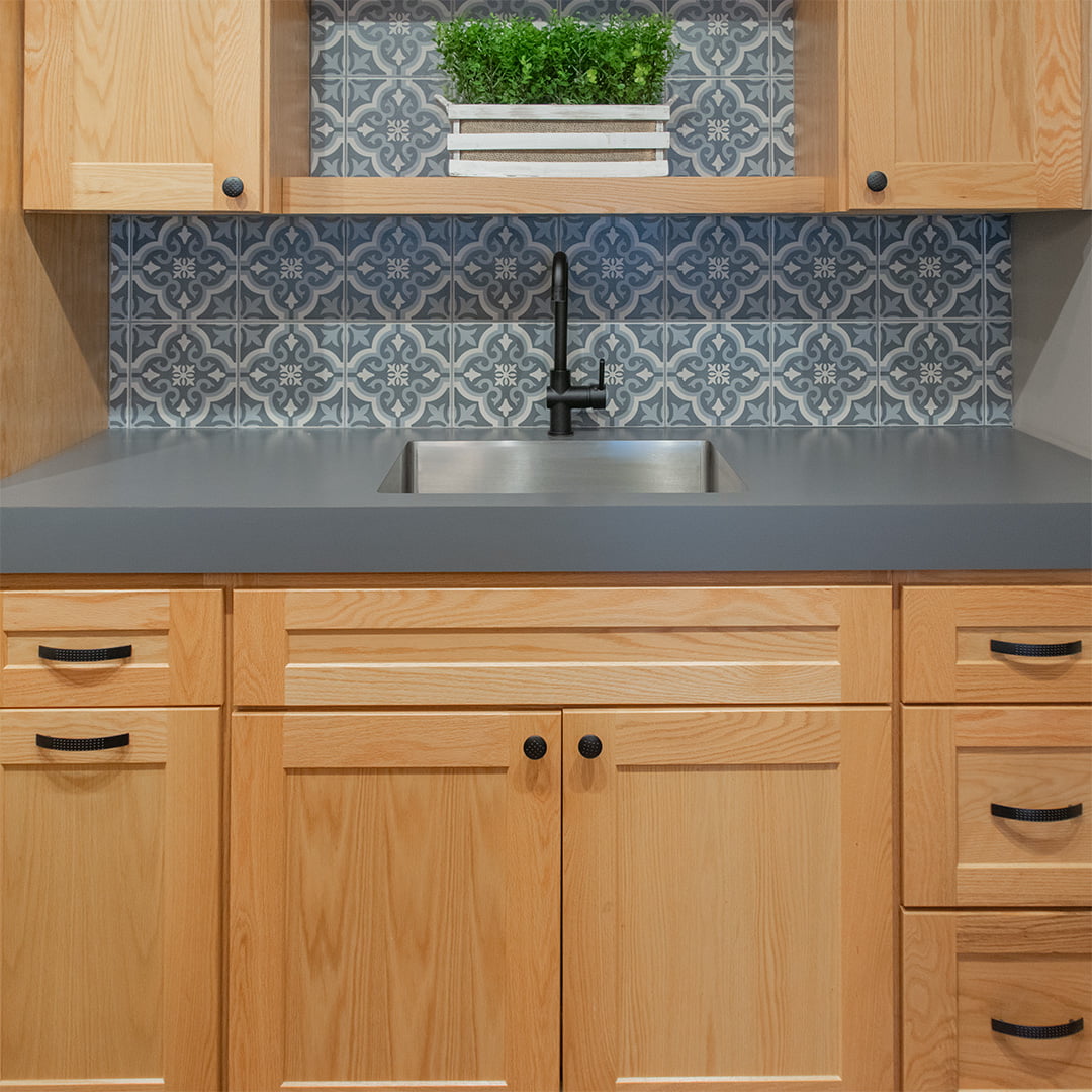 small laundry room sink with black faucet and steel basin