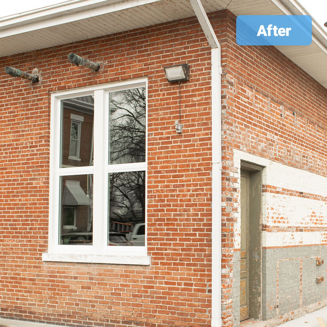 two white vinyl single hung windows on brick boiler building