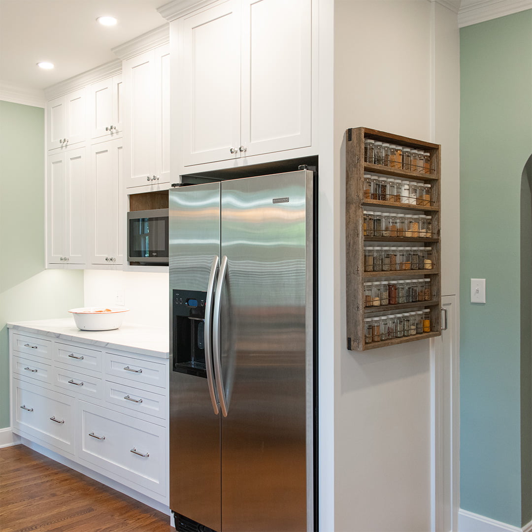 white cabinets in kitchen with green walls and wood floors