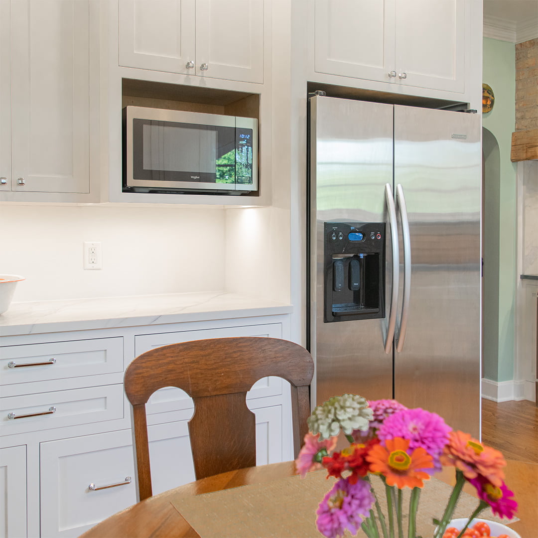 remodeled kitchen with white cabinets and stainless steel refrigerator