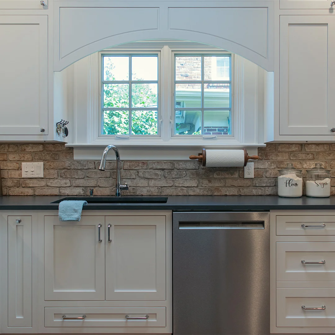 white kitchen cabinets with brick backsplash