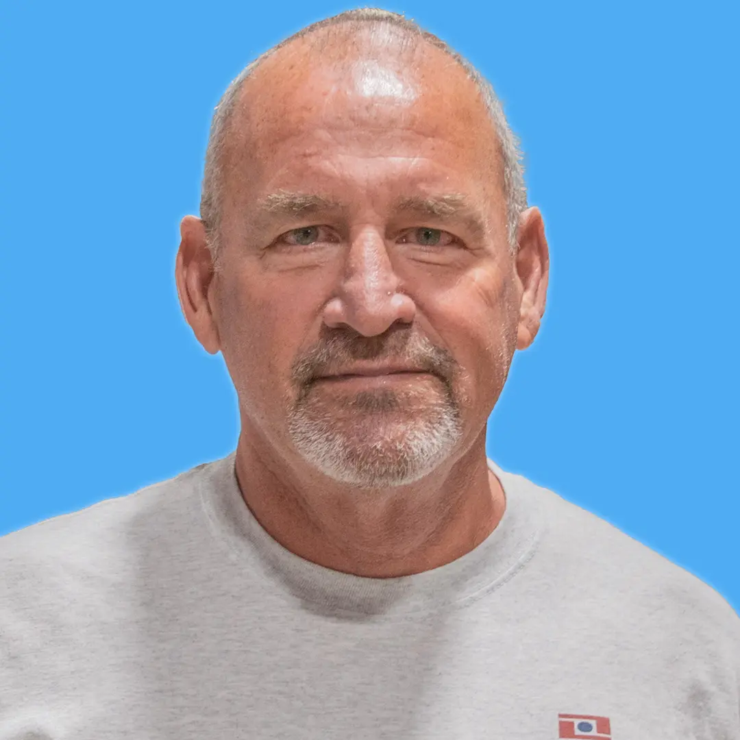 middle-aged male with gray work shirt and gray facial hair