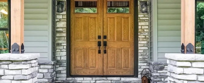 double front door on craftsman-style home with green siding