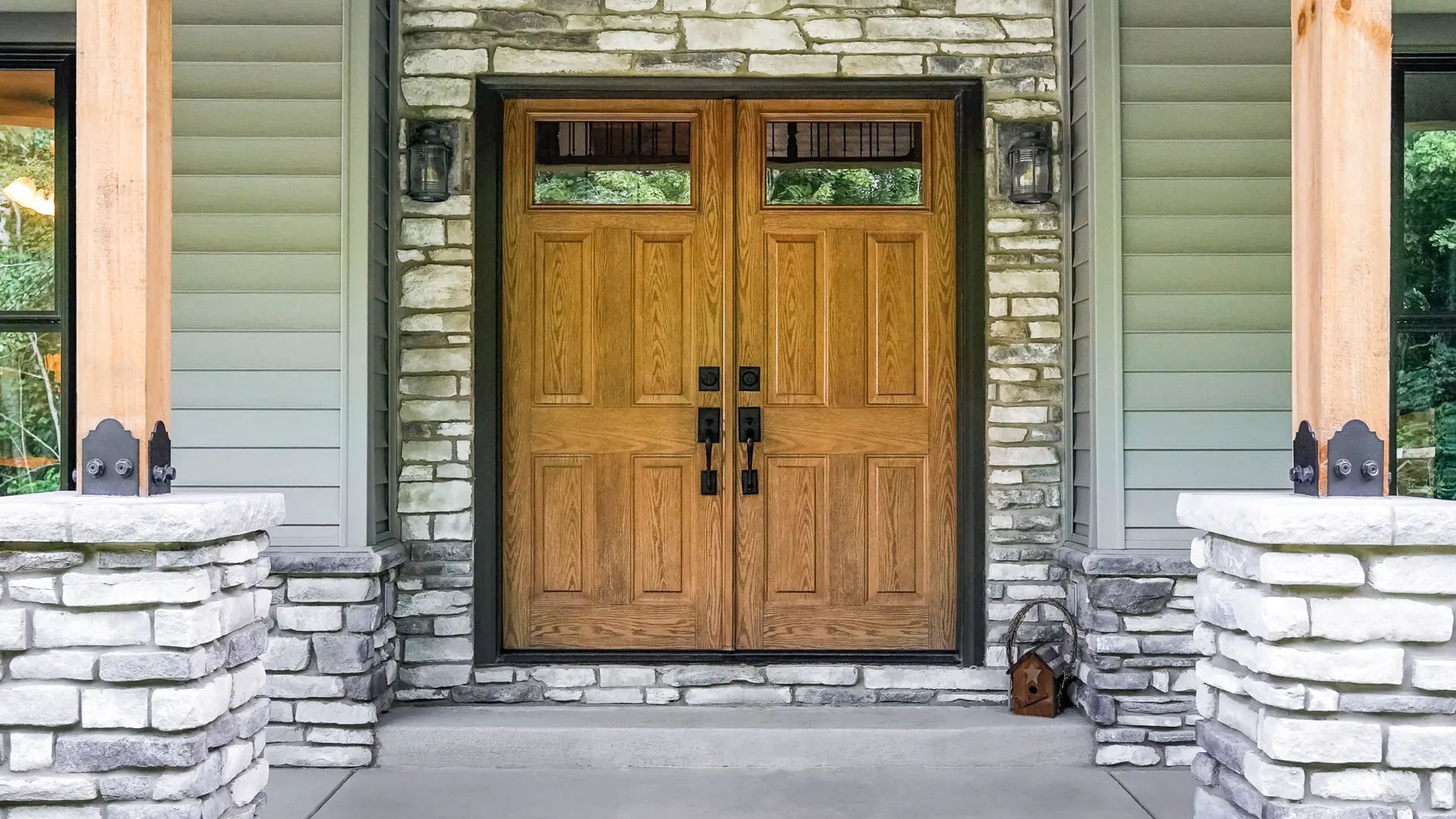 double front door on craftsman-style home with green siding