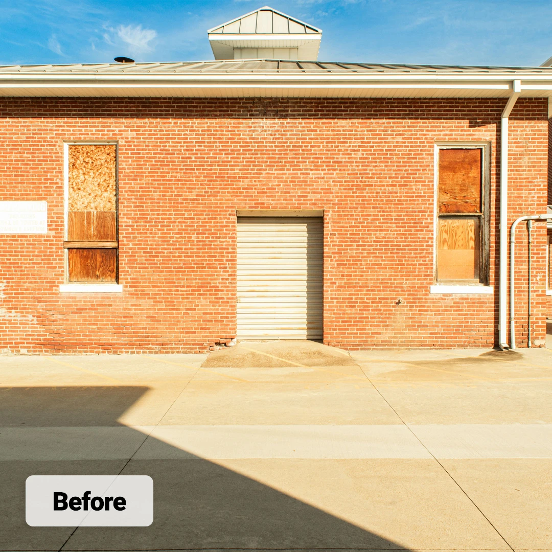 boarded-up windows on historic building with red brick facade