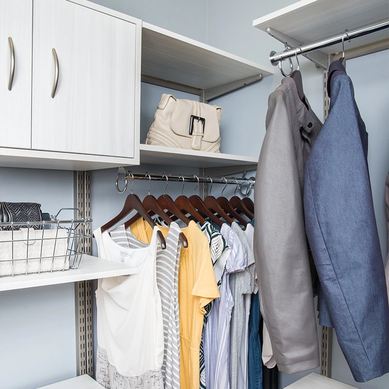 white shelving and storage system inside spacious closet