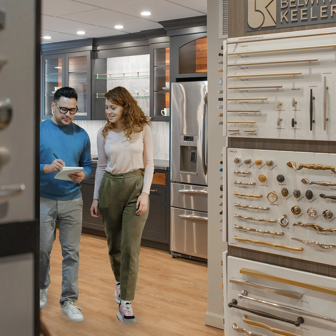 young couple looking at checklist in cabinet showroom